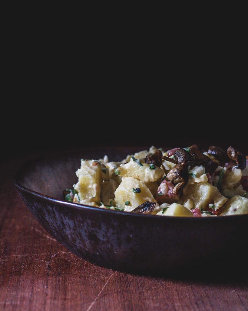 Veganer Kartoffelsalat mit cremigem Dressing, Räuchertofu, Champignons und frischen Kräutern – klassisches Rezept als pflanzliche Beilage.