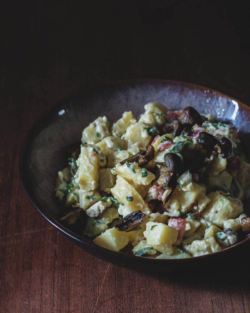 Veganer Kartoffelsalat mit cremigem Dressing, Räuchertofu, Champignons und frischen Kräutern – klassisches Rezept als pflanzliche Beilage.
