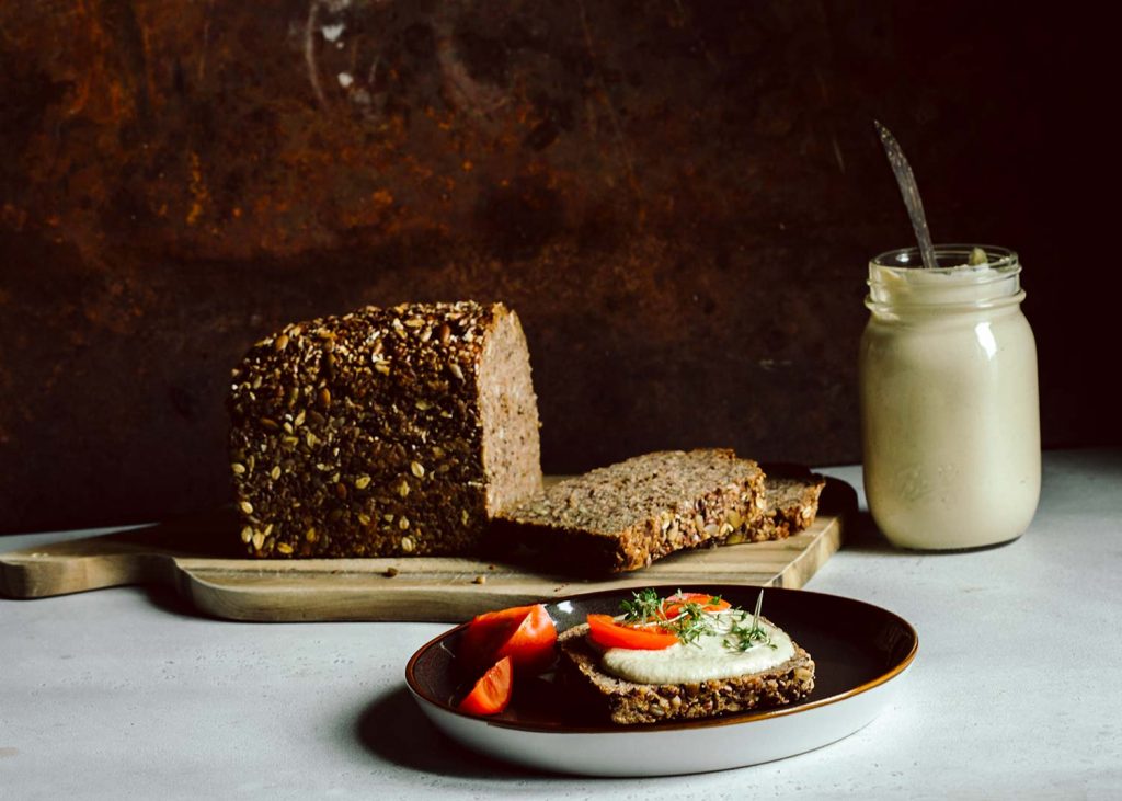 Cremiges veganes Cashew-Aufstrich Rezept auf frischem Vollkornbrot mit Tomaten – einfaches pflanzliches Grundrezept für deinen veganen Alltag. Keyword: vegane Rezept