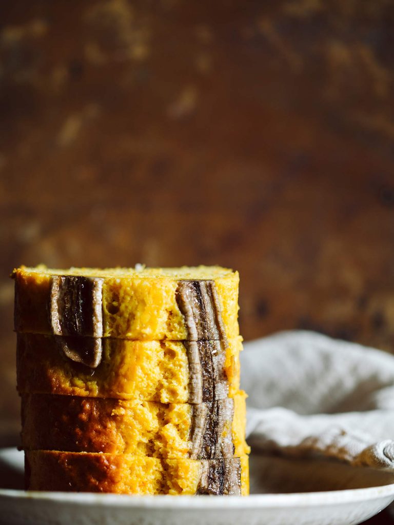Saftiges Kürbis Bananenbrot mit halbierter Banane auf der Oberfläche, frisch in einer Kastenform gebacken