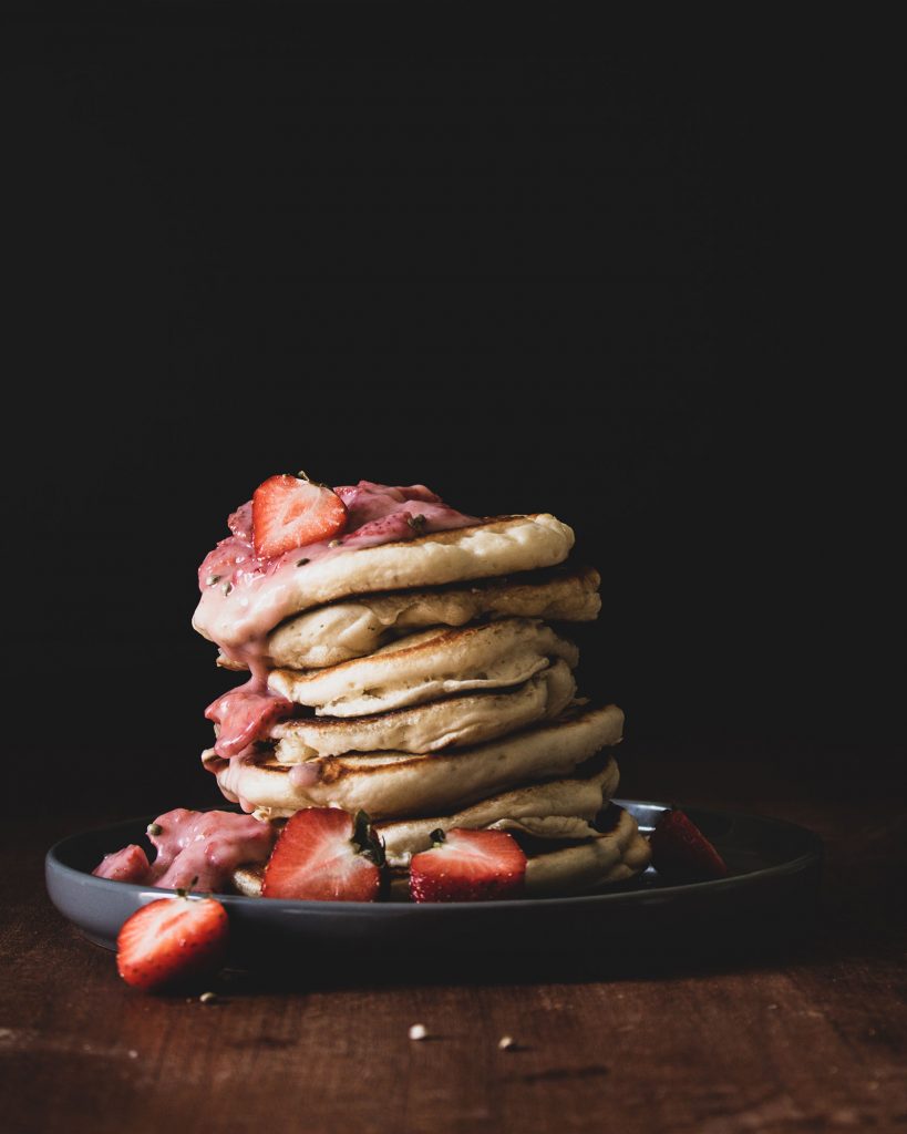 Vegane Pancakes mit Erdbeeren und Vanillejoghurt, serviert als Frühstück oder Brunch