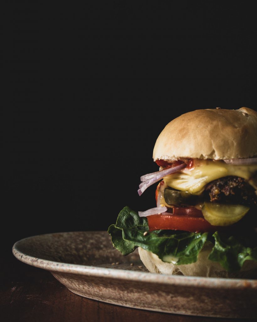 Burger mit selbst gemachten Buns – veganer Linsen-Bohnen-Burger mit geschmolzenem Käse und Salat