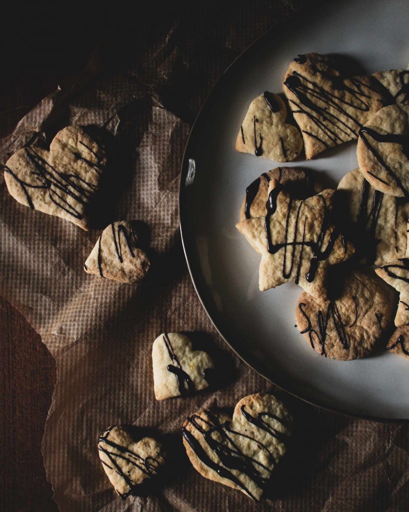 Vegane Weihnachtsplätzchen zum Ausstechen, goldhell gebacken und mit dunkler Schokolade dekoriert