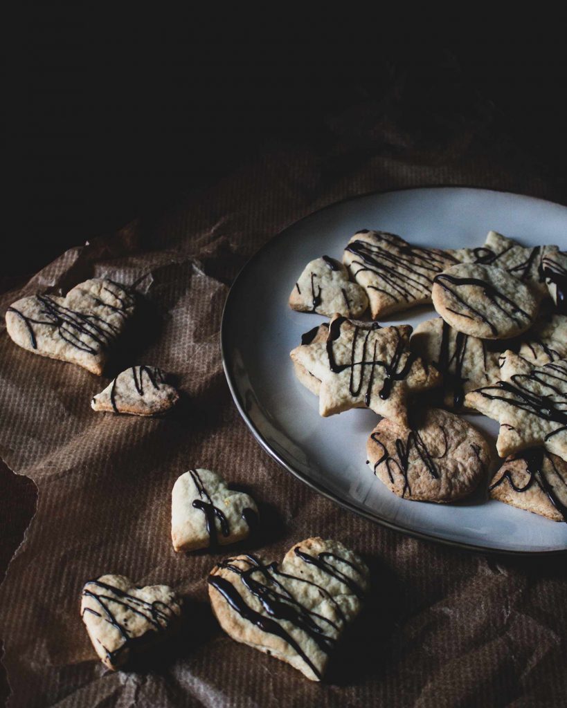 Vegane Weihnachtsplätzchen zum Ausstechen, goldhell gebacken und mit dunkler Schokolade dekoriert
