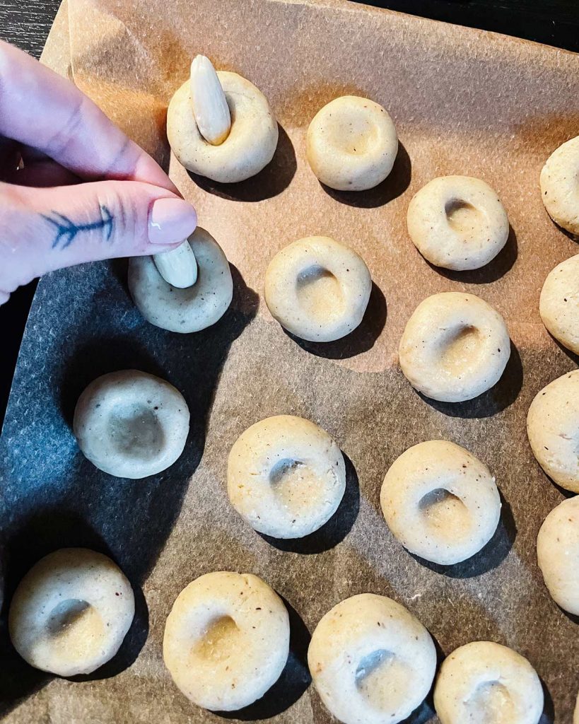 Vegane Weihnachts Cookies mit Mandeln, weißer Schokolade und Zuckerfäden auf einem Backblech