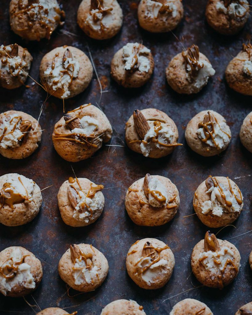 Vegane Weihnachts Cookies mit Mandeln, weißer Schokolade und Zuckerfäden auf einem Backblech