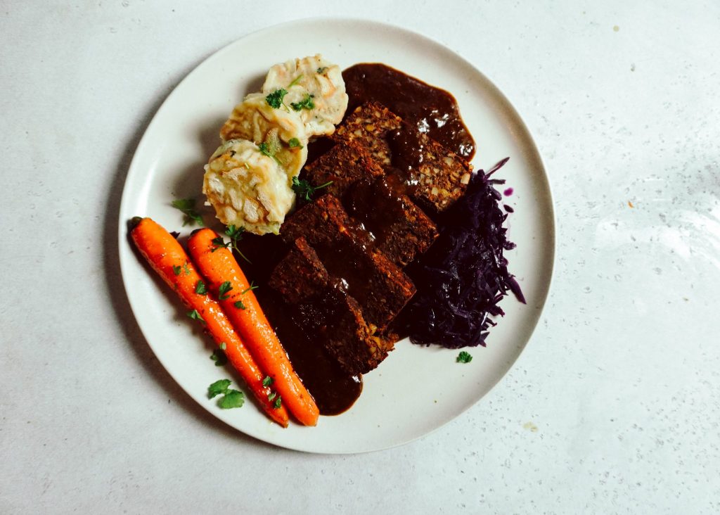 Veganer Nussbraten mit Maronen in Scheiben geschnitten auf einer Servierplatte