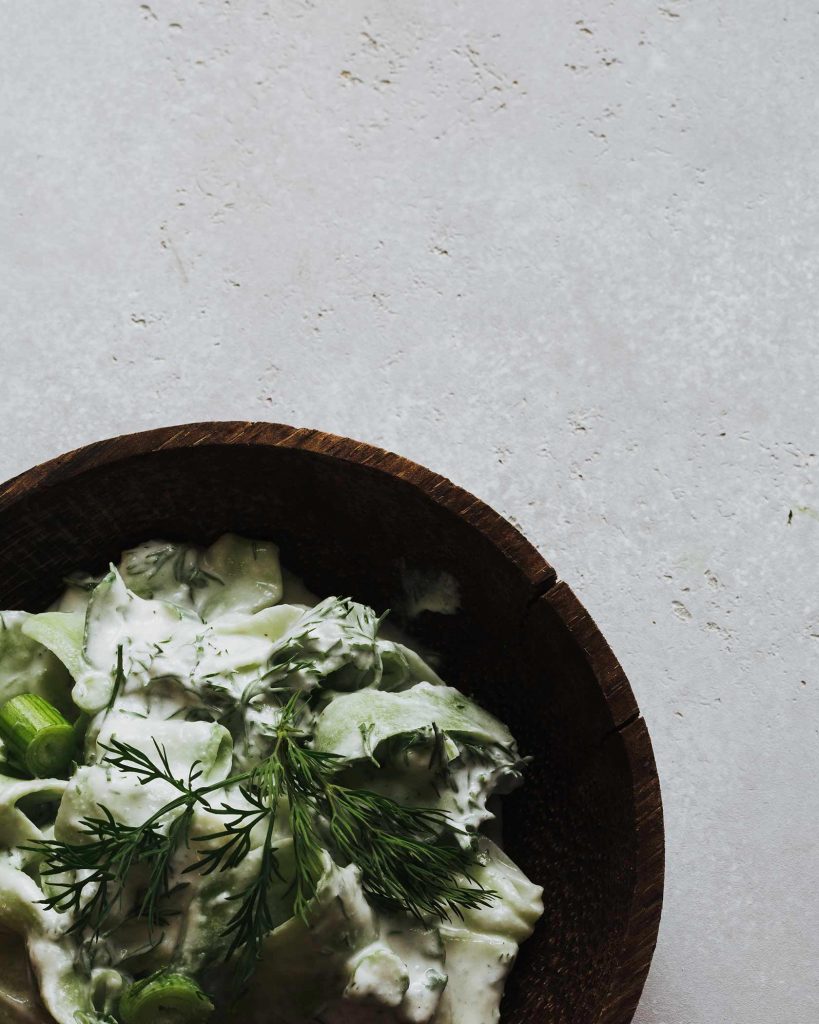 Gurkensalat mit veganem Crème Fraîche Dressing und frischem Dill in Schüssel