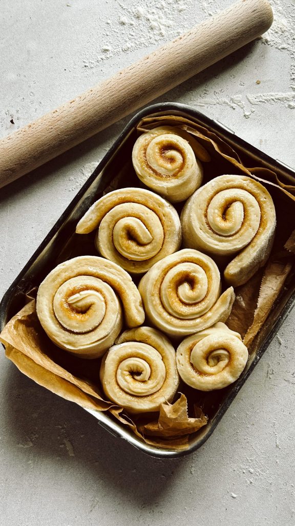 Frisch gebackene vegane Zimtschnecken mit Zuckerguss in einer Form