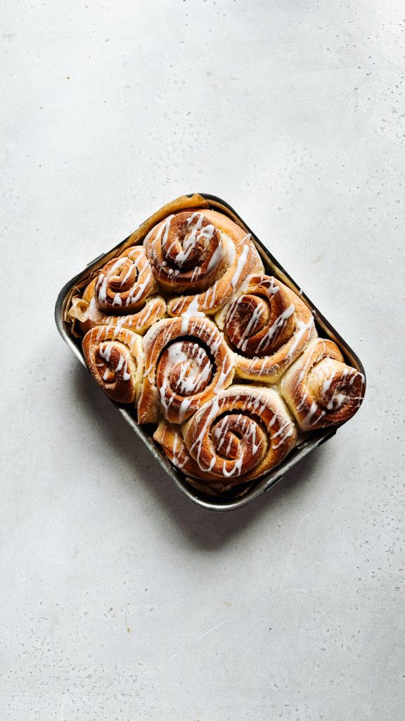 Frisch gebackene vegane Zimtschnecken mit Zuckerguss in einer Form