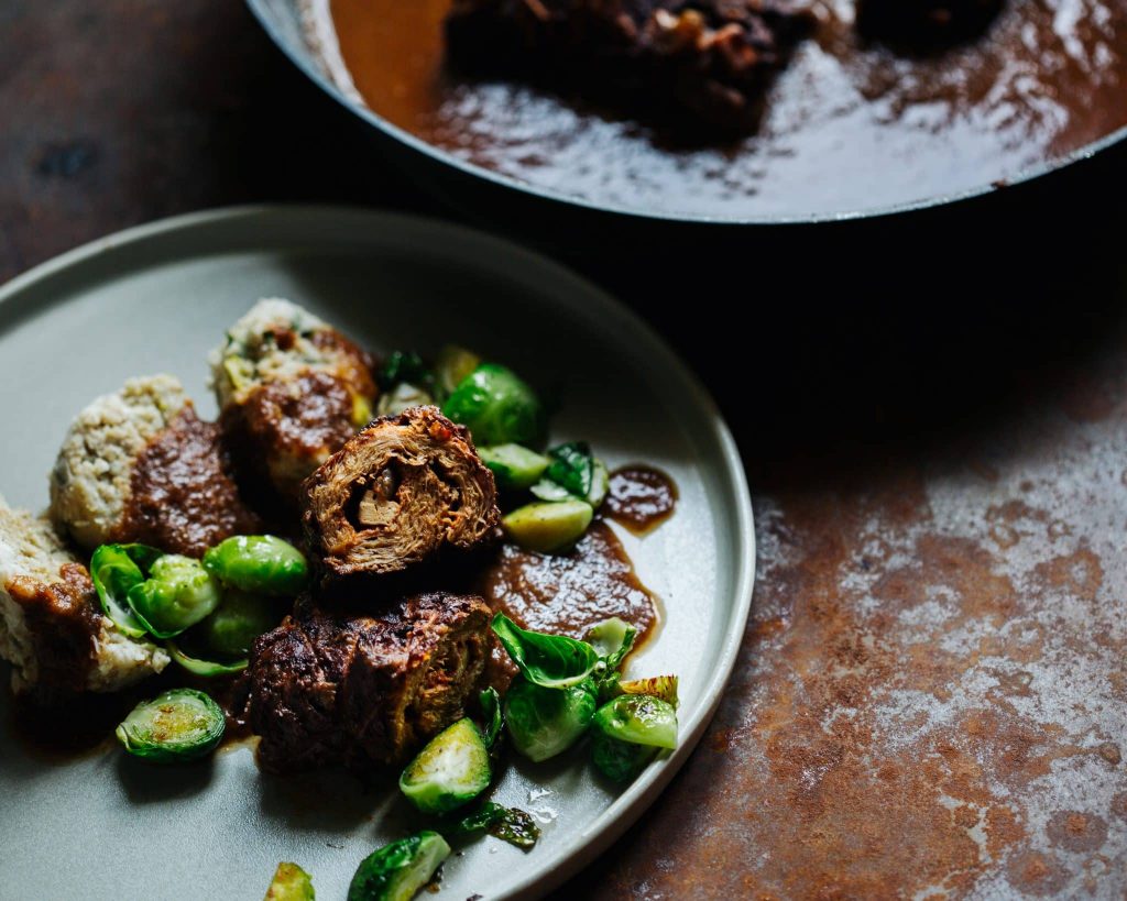 Vegane Rouladen aus Soja mit Füllung und dunkler Bratensauce auf einem Teller serviert