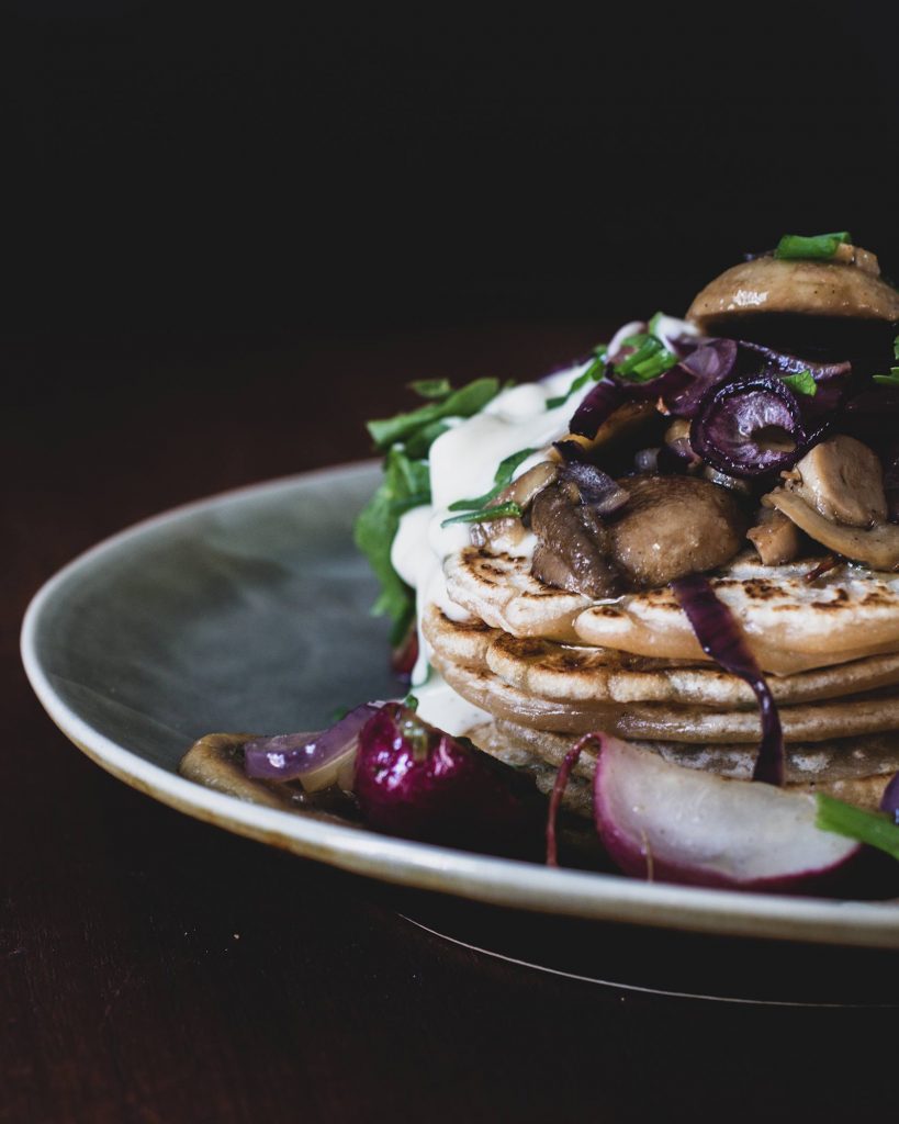 Herzhafte vegane Pancakes mit gebratenem Gemüse und cremigem Dip